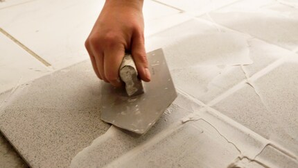 Passez en diagonale sur le carrelage afin de remplir les joints de manière uniforme.