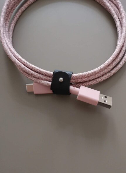 Il cavo è rivestito di un tessuto in nylon e può essere accorciato con un cinturino in pelle.