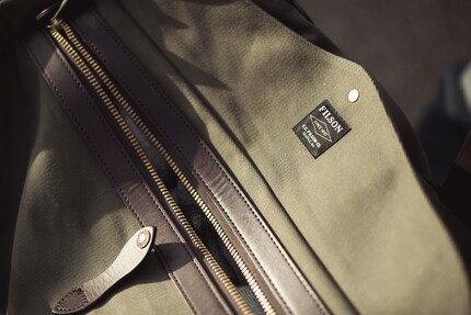 Die durchgehende Sturmklappe (beim Filson-Logo) und der rostfreie Messing-...