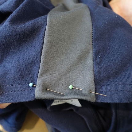 Les aiguilles tiennent le tissu pendant que vous cousez l'ourlet