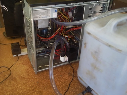 So oder ähnlich haben frühe Wasserkühlungen ausgesehen. Quelle: http://www.comptoir-hardware.com/actus/divers-a-fonkeries/34053-ragotron-le-watercooling-toujours-utile-en-2017-.html
