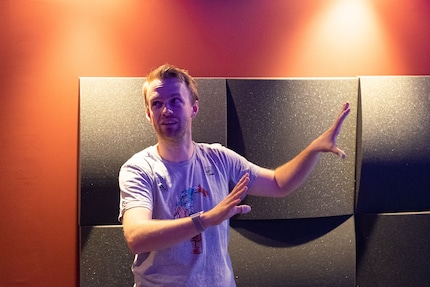 Martin parle de son cinéma. Arrière-plan : les murs rouges en Placoplatre et les absorbeurs.