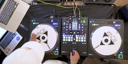 The white discs are jogwheels. Ronfa holds the crossfader between his thumb and index finger. There are knobs and dozens of other buttons in between.