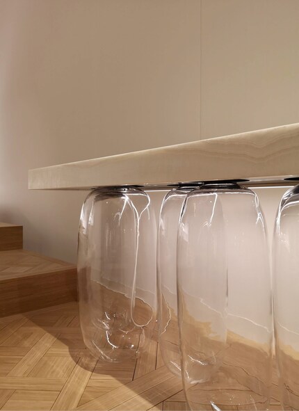 Mundgeblasene Glaskreationen halten minimalistische Marmorblöcke.