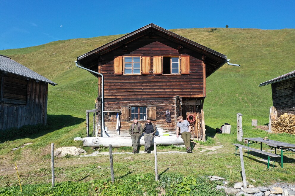 The «men of the house» in front of their hut: Marco, Claudio and Marc.