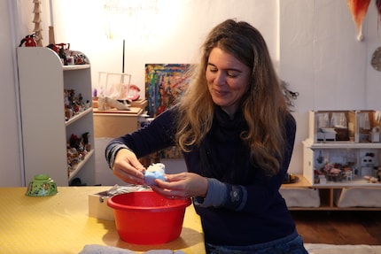 Brigit mescola la creta da modellare. Il colore rosso della vasca non è casuale.
