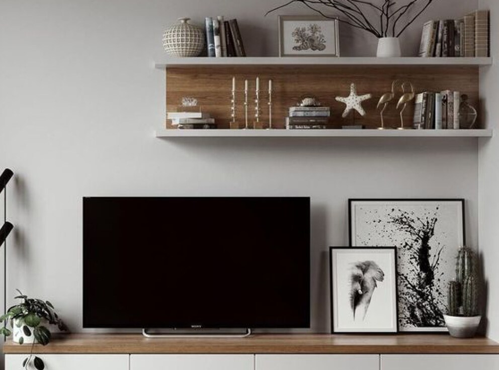 Sur un mur décoré de cadres, le téléviseur attire beaucoup moins l’attention.