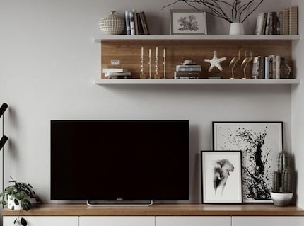Sur un mur décoré de cadres, le téléviseur attire beaucoup moins l’attention.