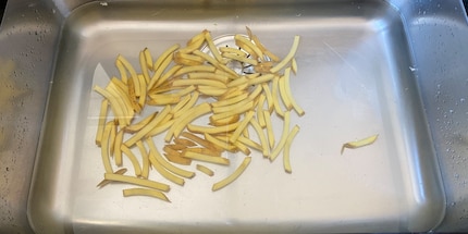 Lavo i bastoncini di patate dopo averli tagliati.