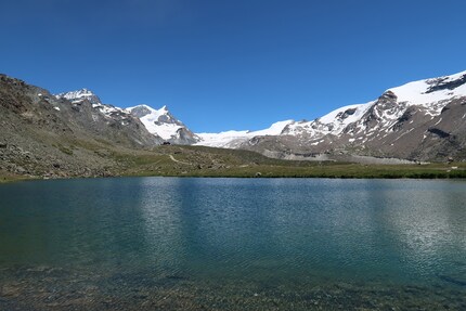 Einer der vielen Bergseen oberhalb Zermatt zwischen Blauherd und Sunnegga. Das Bergrestaurant Fluhalp winzig im Hintergrund.