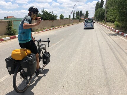 Nos deux cyclistes roulent à travers Döğer masqués et sous escorte policière.