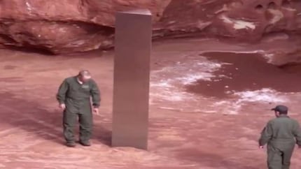 Le membre du personnel semble pointer du doigt quelque chose au sol. Mystérieux.