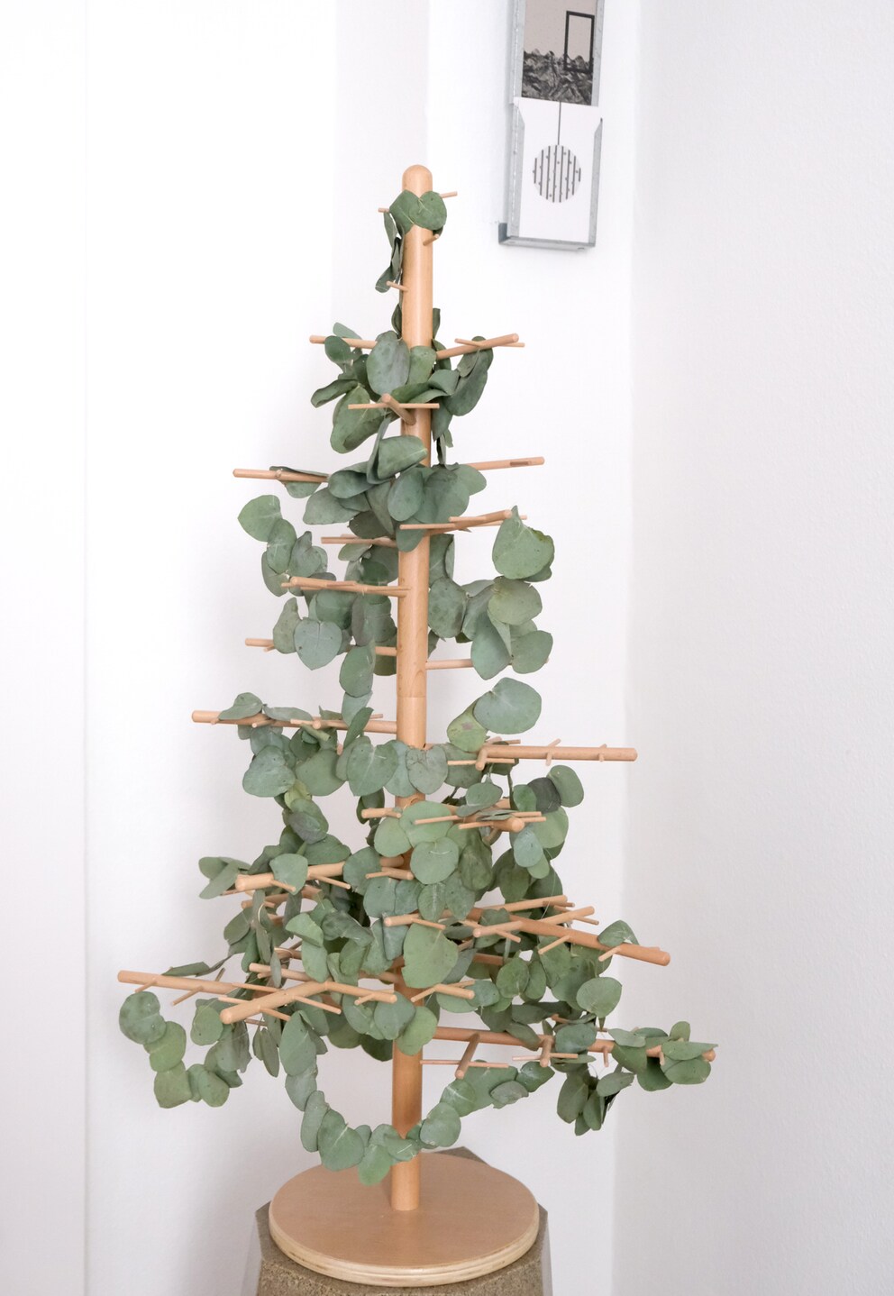 Mit jeder weiteren Girlande wird der Holzbaum grüner.