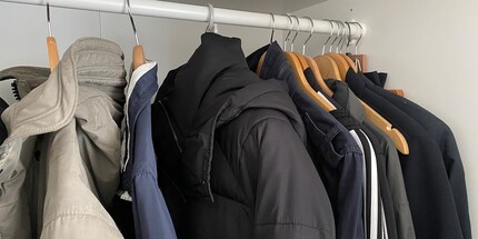 Im Kleiderschrank und an einem Bügel aufgehängt, wartet deine Daunenjacke auf ihren nächsten Einsatz.