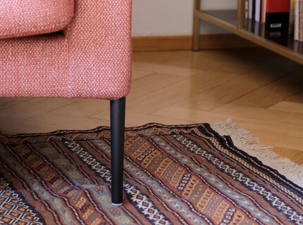 A rug under a sofa or dining table should be large enough so that it’s not a tripping hazard, but a unit.