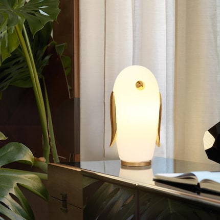 Il pinguino Noot Noot brilla grazie agli elementi in ceramica dorata. Immagine: Moooi