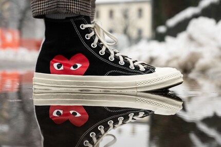 Il logo del cuore rosso è caratteristico del marchio di moda giapponese Comme des Garçons. Sostituisce la tipica toppa delle Chucks sui modelli Comme des Garçons Play x Converse. Immagine: Reddgio/Unsplash
