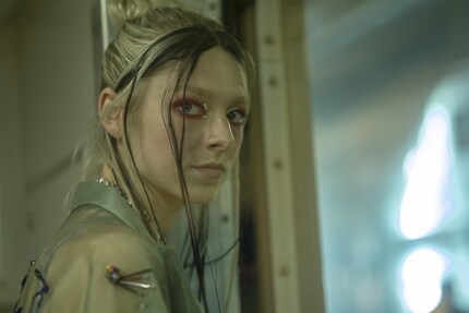 Jules Vaughn (Hunter Schafer) in rotem Lidschatten mit grafischen Akzenten.