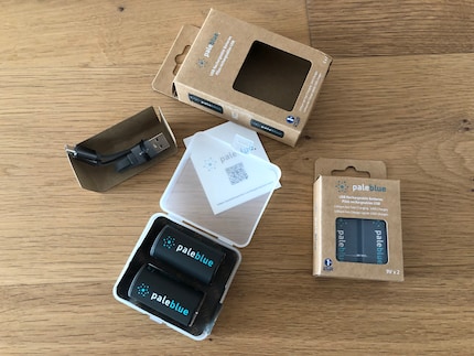 Pale Blue confeziona la scatola di plastica dura con le batterie e il cavo per la ricarica in una scatola di cartone.