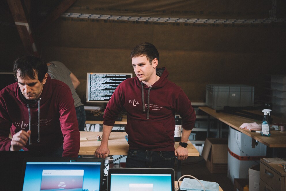 Tobias Schär dans la pièce où les vieux ordinateurs portables sont remis en état pour une deuxième vie. À gauche sur la photo : David Werder, réparateur bénévole.