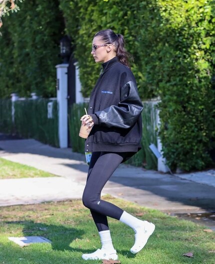 Bella Hadid mit Kaffee in der Hand und Crocs an den Füssen.
