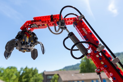 Le bras articulé de la grue avec le grappin ouvert.