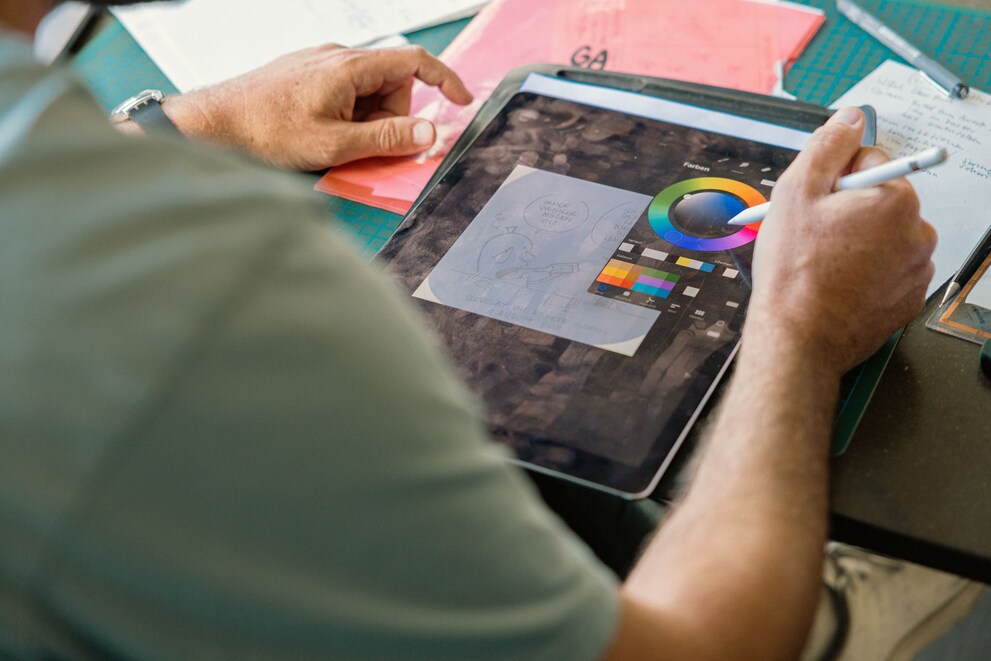 He colours in his pencil drawings on his iPad.