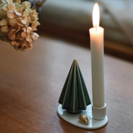 Petit, mais mignon : le sapin en céramique brille grâce à la lueur de la bougie.