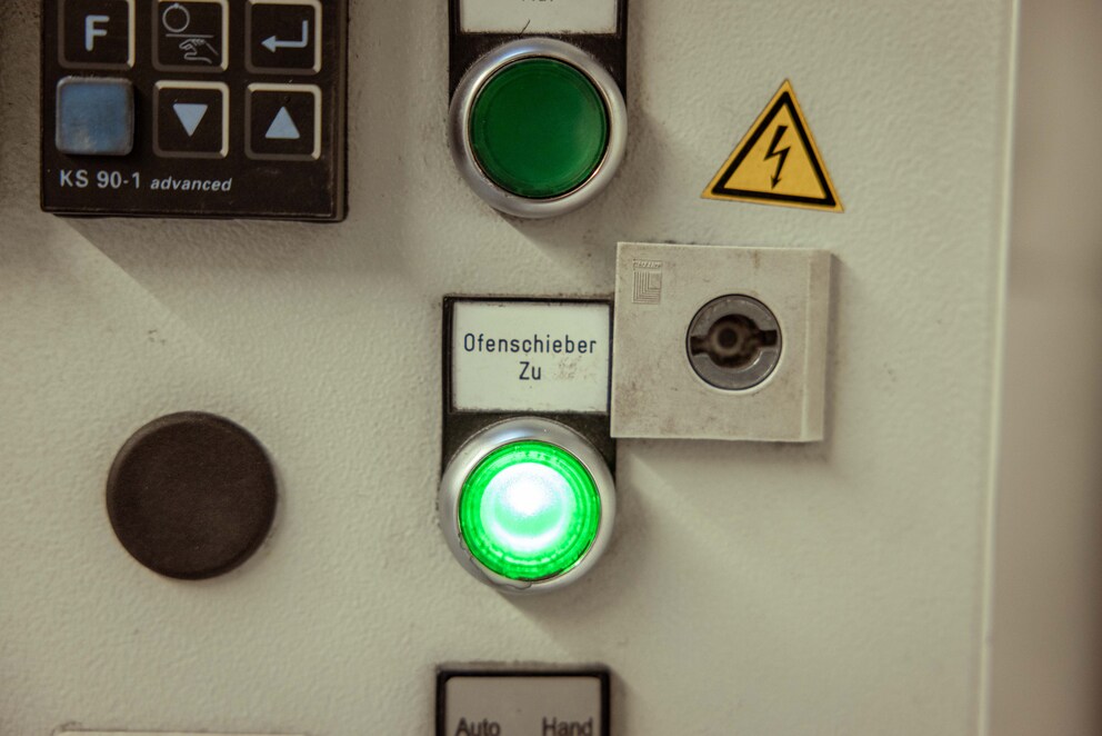 Der sehr technische Kremationsbereich ist durch eine schwere Türe vom durchdacht gestalteten Wartebereich getrennt.