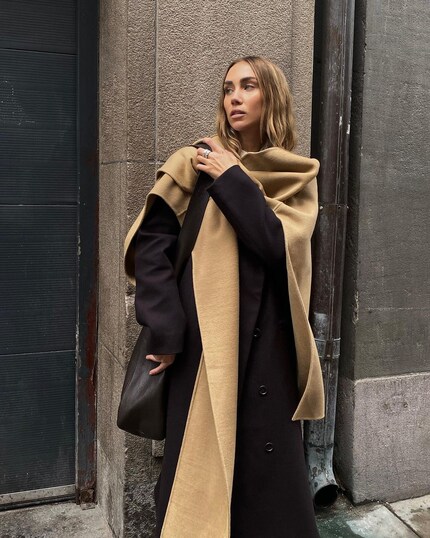 La créatrice de bijoux Lisa Olsson drape son poncho comme une écharpe.