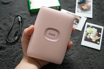 La Instax sta bene nella mia mano e ha un grande pulsante di accensione sul fronte.