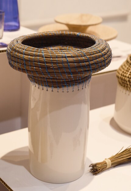 Eneida Lombe Tavares Raiz intreccia aghi di pino su ceramica.