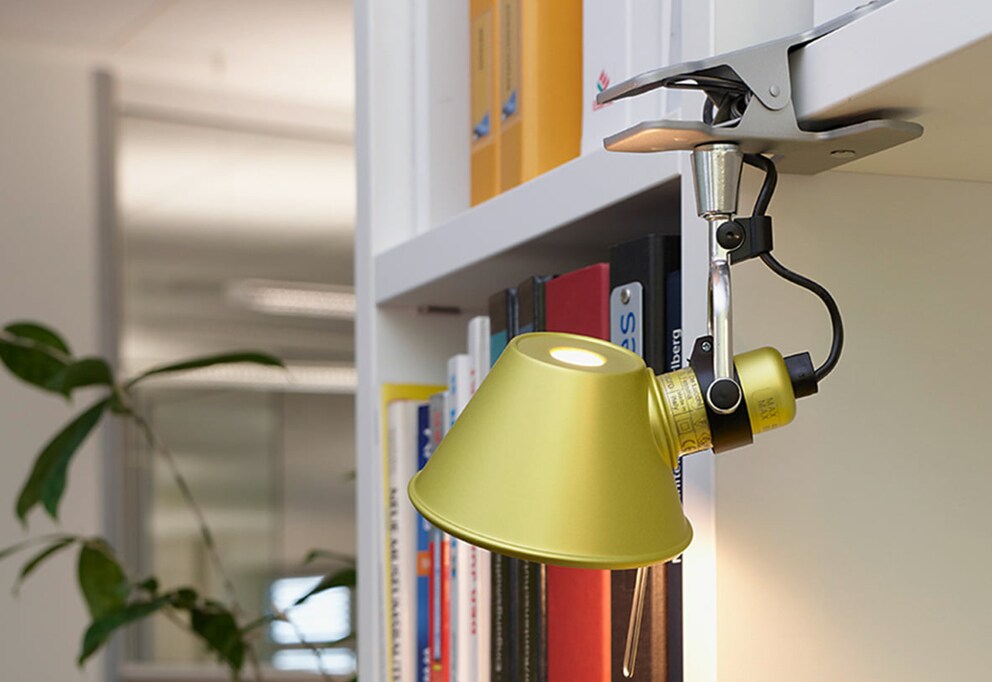 La lampada a pinza «Tolomeo Pinza Micro» fa capolino dalla mensola e la mette visivamente in risalto.