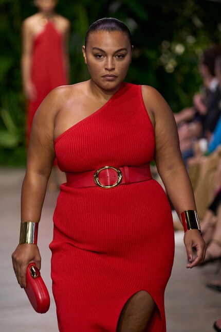 An asymmetric red dress and statement bangles - a trendy combination at Michael Kors for summer '23.