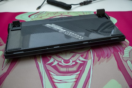 La parte inferiore dell'Asus ROG Azoth è in plastica. Qui si trovano anche i piedini per la regolazione dell'angolo di battitura.