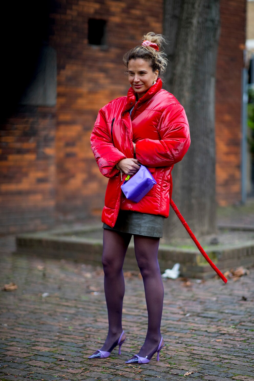 Violette Strümpfe und eine knallrote Pufferjacke – klingt wild, sieht aber erstaunlich harmonisch aus.