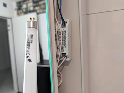 Ein elektronisches Vorschaltgerät in einem Spiegelschrank, das drei Röhren steuert.