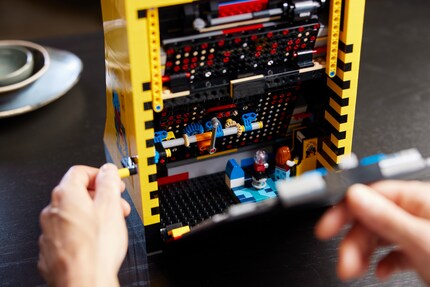 The back of the Lego set is removable. Not only can you take a look at the game mechanics, but there's also a little surprise waiting for you: a mini Lego man is immersed in his Pac-Man game.