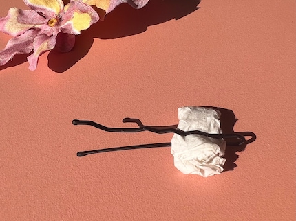 Klemme etwas Papier in den Bobby Pin, um ihn offen zu halten.