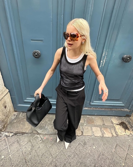 Le débardeur blanc forme un beau contraste sous le tricot noir. 