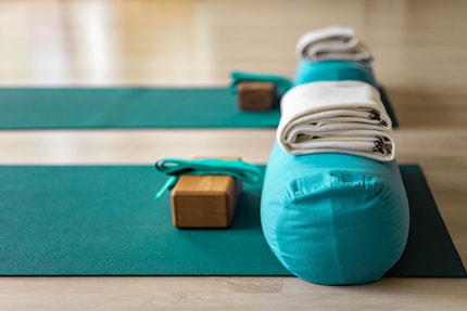 Den typischen Yoga-Block (links) kennen viele. Das Yoga-Bolster (rechts) ist da noch unbekannter.