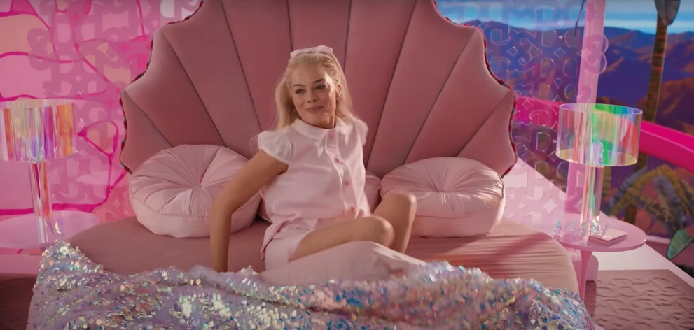 Au lieu des oreillers classiques, le lit de Barbie est couvert de coussins ronds en velours rose. 