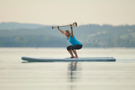 Le gambe si scaldano!  Gli squat sulla tavola da SUP favoriscono la forza e l'equilibrio.