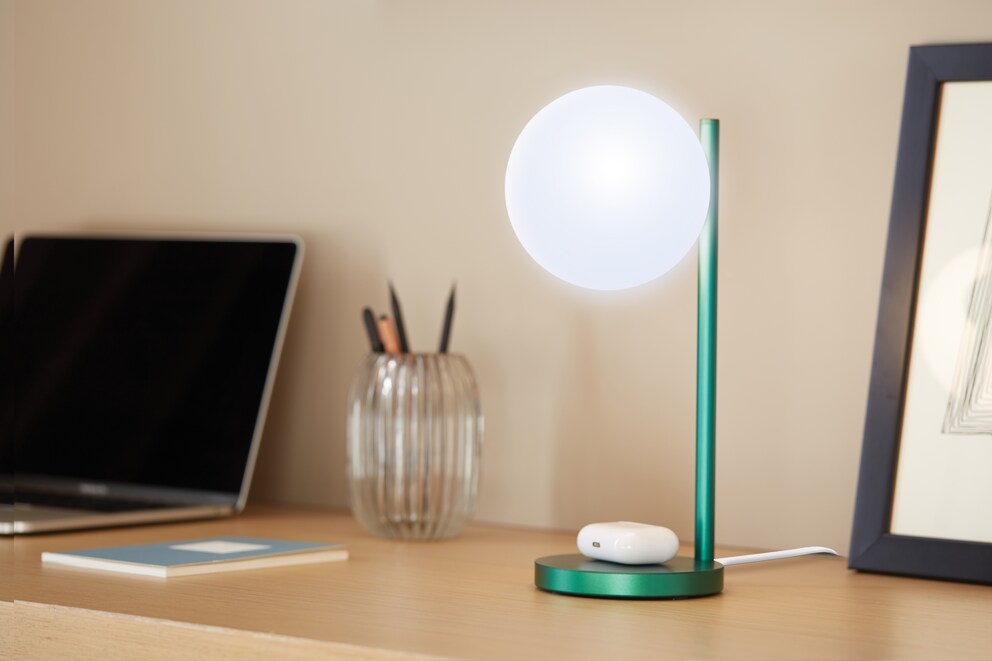 Das Licht fürs Büro lädt auch gleich Handy oder Kopfhörer drahtlos auf.