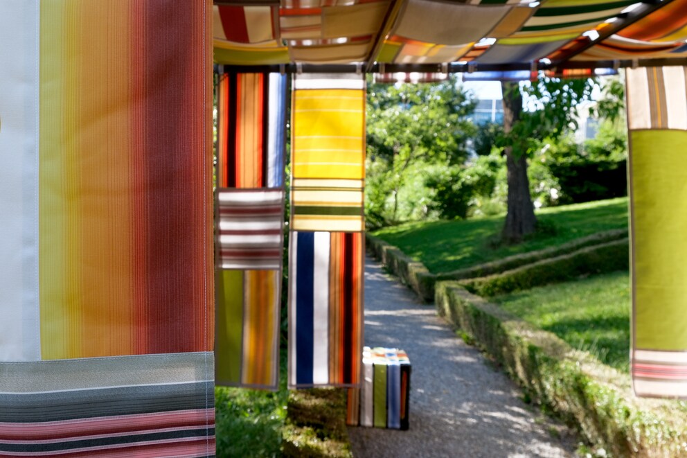 Bei seiner Installation «Brise» bilden Vorhänge aus alten Markisen einen Pergola-artigen Raum.