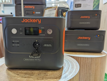Jackery Explorer 1000 Plus avec des Battey Packs en arrière-plan.
