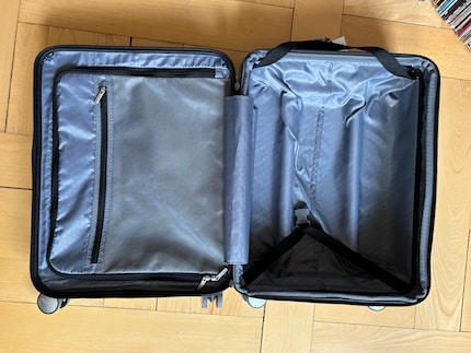 La valise compte deux grands compartiments, un filet, une pochette zippée et des sangles.