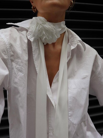 Influencer Millie Holmes combines a white fabric flower with a white blouse - a perfect match.