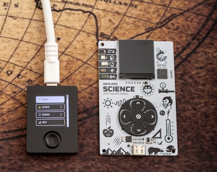 L’Oxocard Connect (gauche) est beaucoup plus petite que l’Oxocard Mini. Le joystick est moins facile à utiliser que les grandes touches directionnelles.