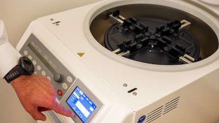 Il medico imposta la centrifuga a cinque minuti.